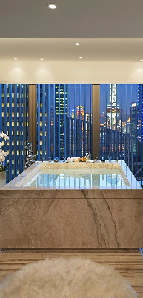 a bathtub placed into a stone slab for a chic and unusual look
