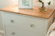 03 a charming nightstand in white, with glass knobs and a wooden countertop of IKEA Rast