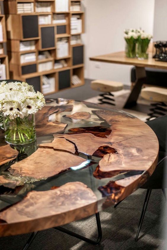 a stunning round dining table with live wood edge and resin  and metal legs is a centerpiece here