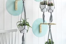 34 IKEA Frosta stools attached to the cardboard circles and to the wall to hang some planters create a bold composition