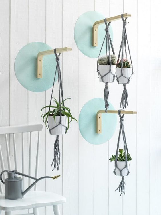IKEA Frosta stools attached to the cardboard circles and to the wall to hang some planters create a bold composition