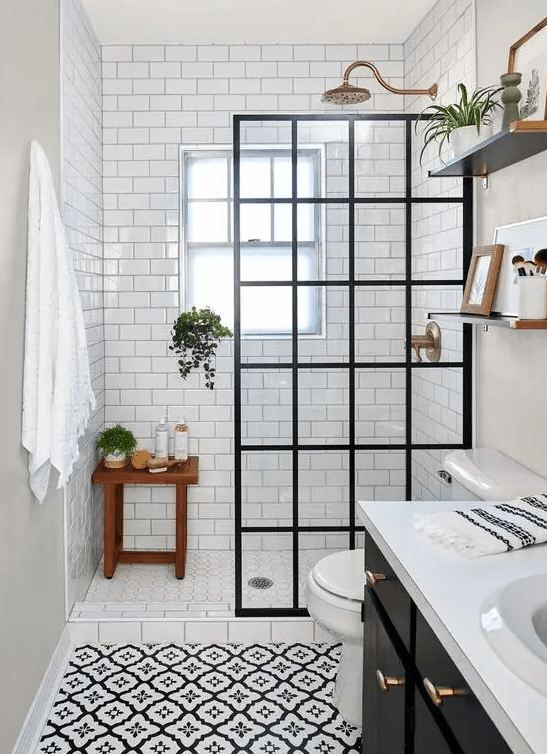 a vintage-inspired bathroom with white subway tiles and printed ones, a shower space with a screen, a black vanity and shelves
