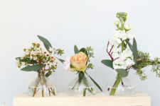 DIY bud vases of Christmas ornaments on a wooden stand