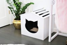 DIY white plywood cat litter box cover with a cat head entry and a striped roof