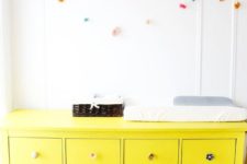 17 a neon yellow IKEA Hemnes dresser with all different knobs as a changing table for a colorful kids’ space