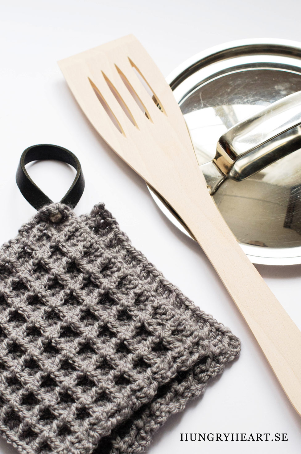 DIY dark waffle crochet potholder with a leather loop