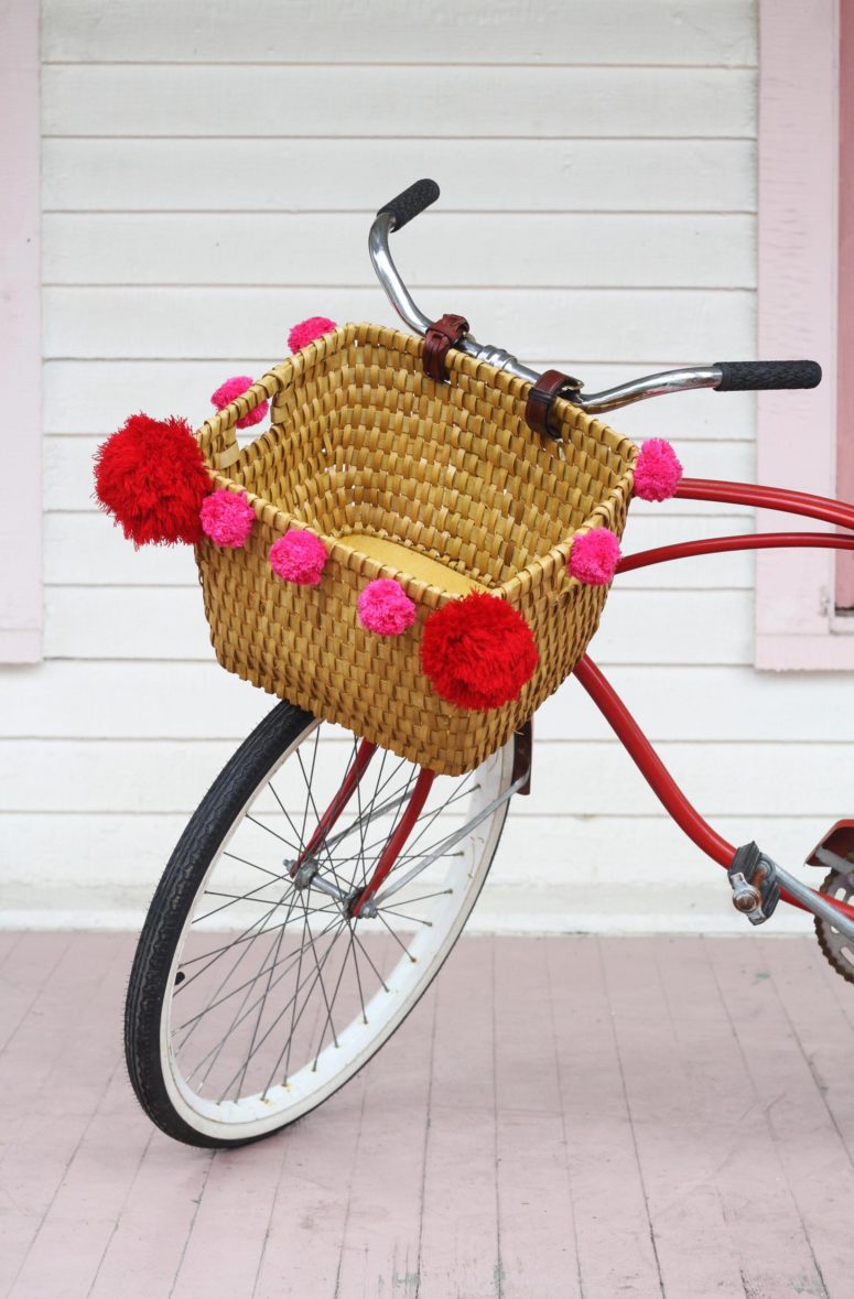 DIY bike basket with large pompoms  (via www.apartmenttherapy.com)