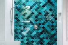 a bright statement wall made of fish scale tiles of different shades of turquoise