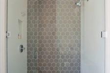 10 a minimalist bathroom with a shower statement wall done with grey hex tiles with white grout
