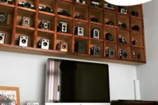 02 an oversized box shelf display with a compartment for each camera is a bold decor feature