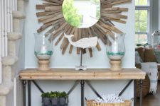 a coastal entryway with a starburst mirror clad with driftwood for a cool natural look