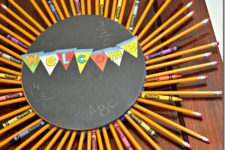 DIY back to school wreath with a chalkboard base, crayons and pencils
