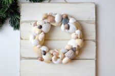 DIY coastal artwork of wood and a sea shell wreath