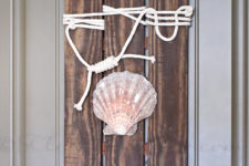 DIY coastal pallet art with rope and a large sea shell