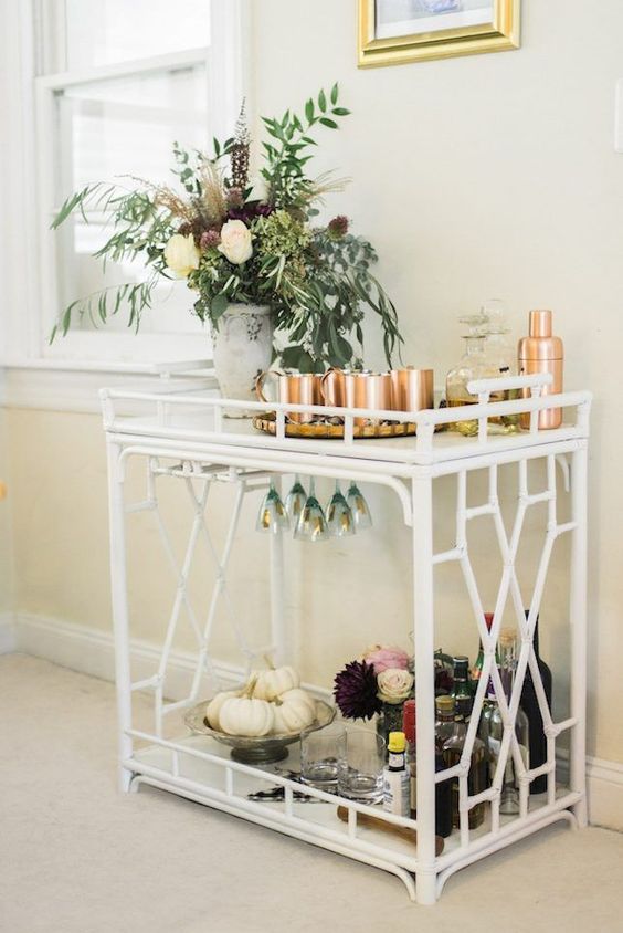 a bar cart with gorgeous fall floral arrangements, white pumpkins in a bowl and copper barware