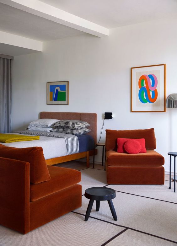 rust-colored velvet chairs add color and interest to this mid-century modern space