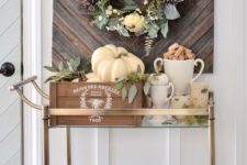 10 a fall bar cart styled with crates, birch bark candle holders, pumpkins and eucalyptus for fall
