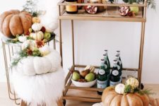 13 a gorgeous fall bar cart with a bright floral arrangement, pumpkins, pomegranates and pears in a bowl