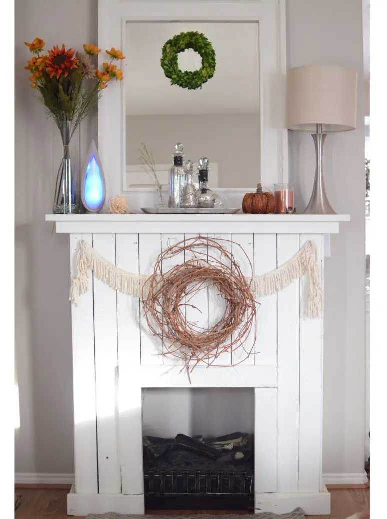 DIY pallet wood fireplace with a black mantel (via www.nonishouse.com)