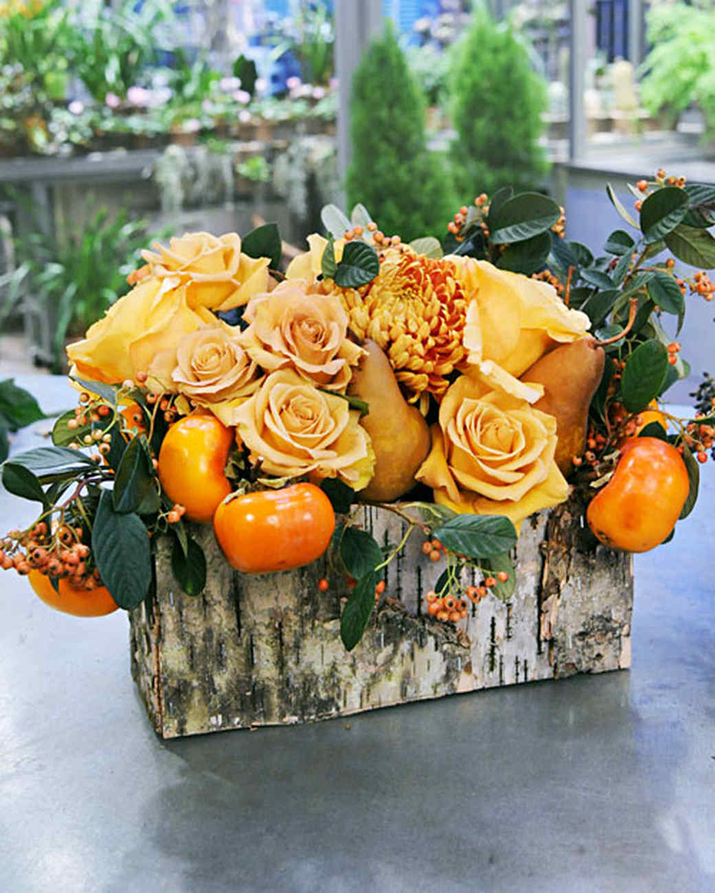 DIY orange toned arrangement with greenery in a birch vessel