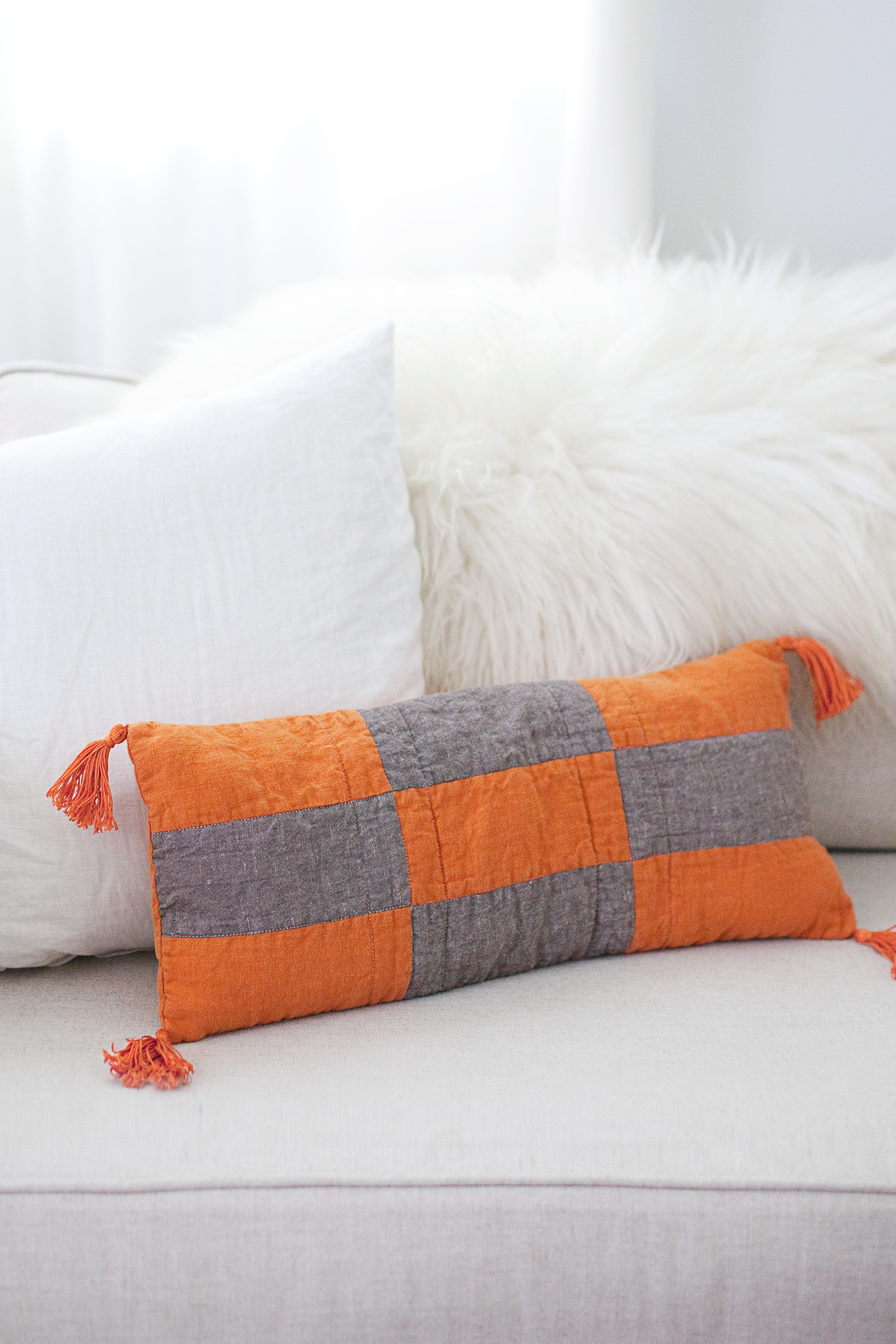 DIY modern patchwork pillow in grey and orange (via abeautifulmess.com)