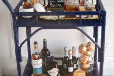 a Thanksgiving bar cart with wheat, gilded pumpkins and a candle in a candle holder
