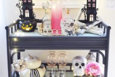 a bold Halloween bar cart with LEDs, skulls, pumpkins and black houses plus pink touches