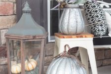 a large vintage lantern of wood with natural pumpkins inside is a gorgeous idea for a vintage or rustic porch