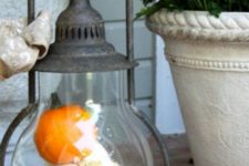 a whimsy vintage lantern with fake pumpkins is a great decoration for porches or tables