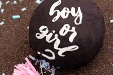 DIY gender reveal pinata of a black ball and with clothes inside