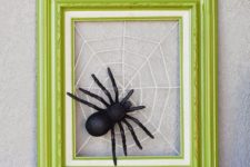 DIY Halloween wreath or artwork of a neon frame and spiderweb with a spider