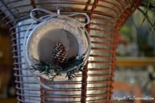 DIY Christmas ornament of a wooden ring, a pinecone and fake evergreens