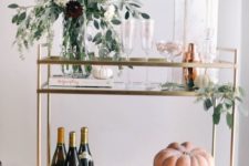 simple styling with a fall flower arrangement, pumpkins and eucalyptus plus tall glasses