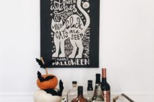 simple styling with a stack of pumpkins and black bats plus some fake spiderweb and a sign