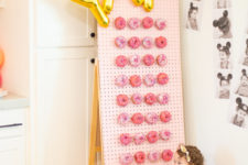 DIY donut wall with letter balloons and pink donuts