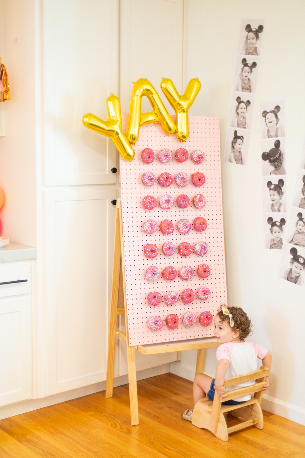 DIY donut wall with letter balloons and pink donuts