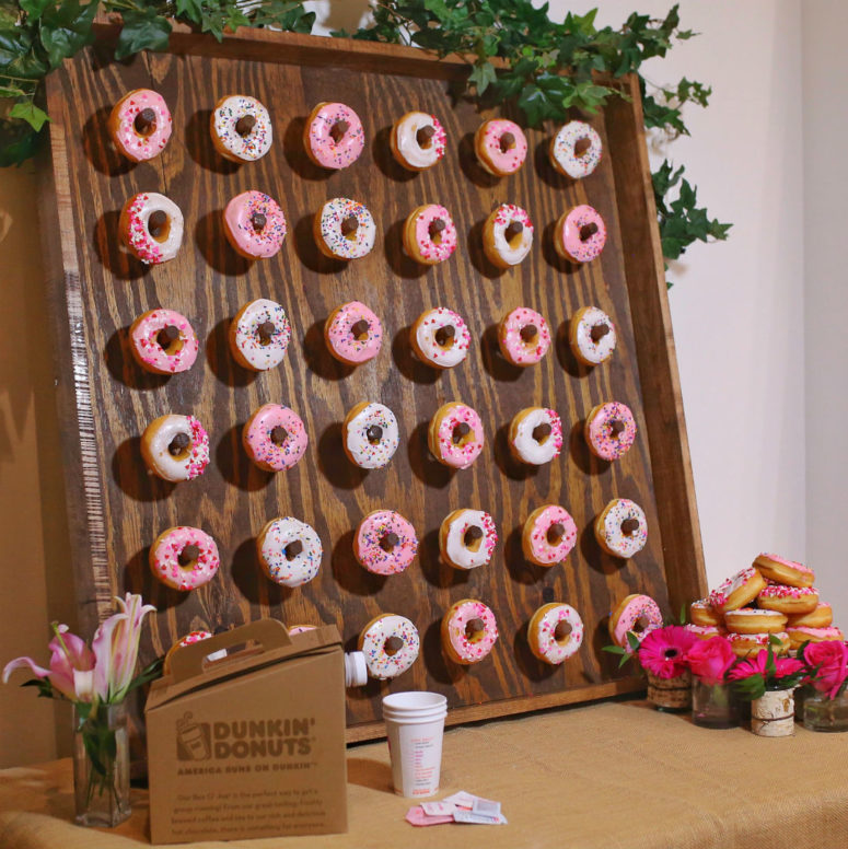 DIY mini donut wall of dark plywood decorated with greenery (via thehouseofsequins.com)