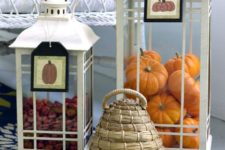 white lanterns with tags filled with real berries and fake orange pumpkins are amazing for fall decor
