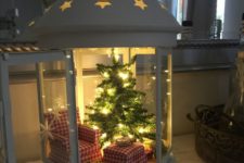 05 a large lantern with a wintry look, a plaid chair with an ottoman and a tree with lights
