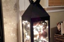 07 a black lantern filled with ornaments and lights is a very easy to realize idea