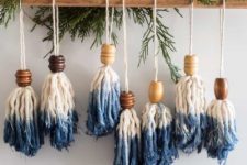 07 blue dipped tassel and bead Christmas ornaments hung on a wooden stick with fresh evergreens