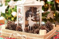 08 a chic white Christmas lantern with ornaments, pinecones and a deer silhouette