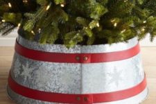 14 a galvanized metal tree collar with snowflakes and red ribbons on the whole diameter