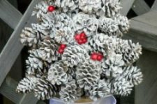 14 a whitewashed pinecone Christmas tree with a red fake bird on top and red berries for a shabby chic look