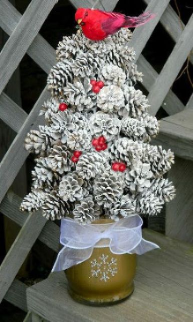 a whitewashed pinecone Christmas tree with a red fake bird on top and red berries for a shabby chic look