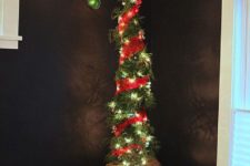 16 a tall Grinch Christmas tree decorated with lights and red burlap plus a single green ornament on top