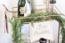 02 a bar cart with a lush evergreen garland, a tinsel Christmas tree and some drinks and pomegranates