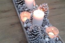 02 a whitewashed display with pinecones, beads and other stuff plus candles for a winter wonderland touch