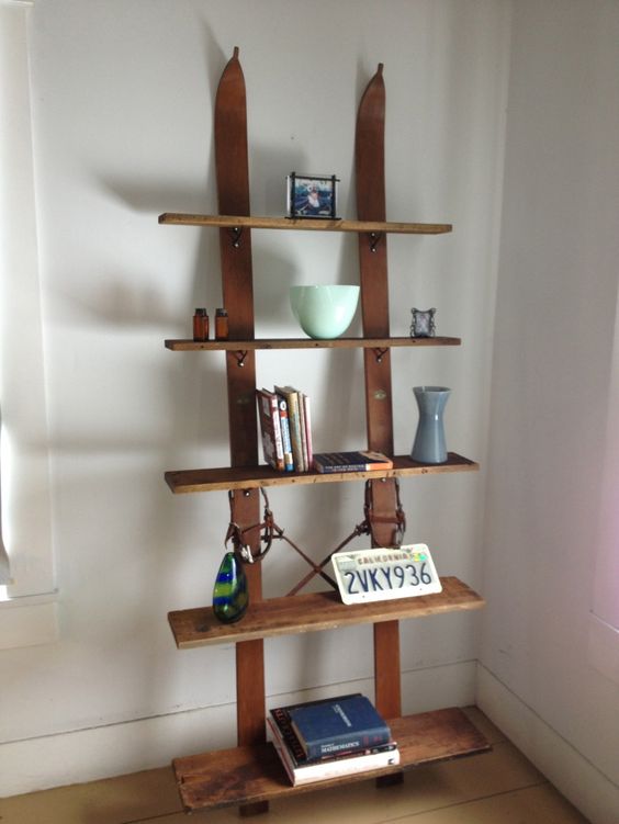an open shelving unit with skis as a base is a cool way to upcycle your old skis