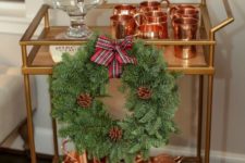 06 cozy decor with an evergreen and pinecone wreath, copper mugs and a tan with cranberry